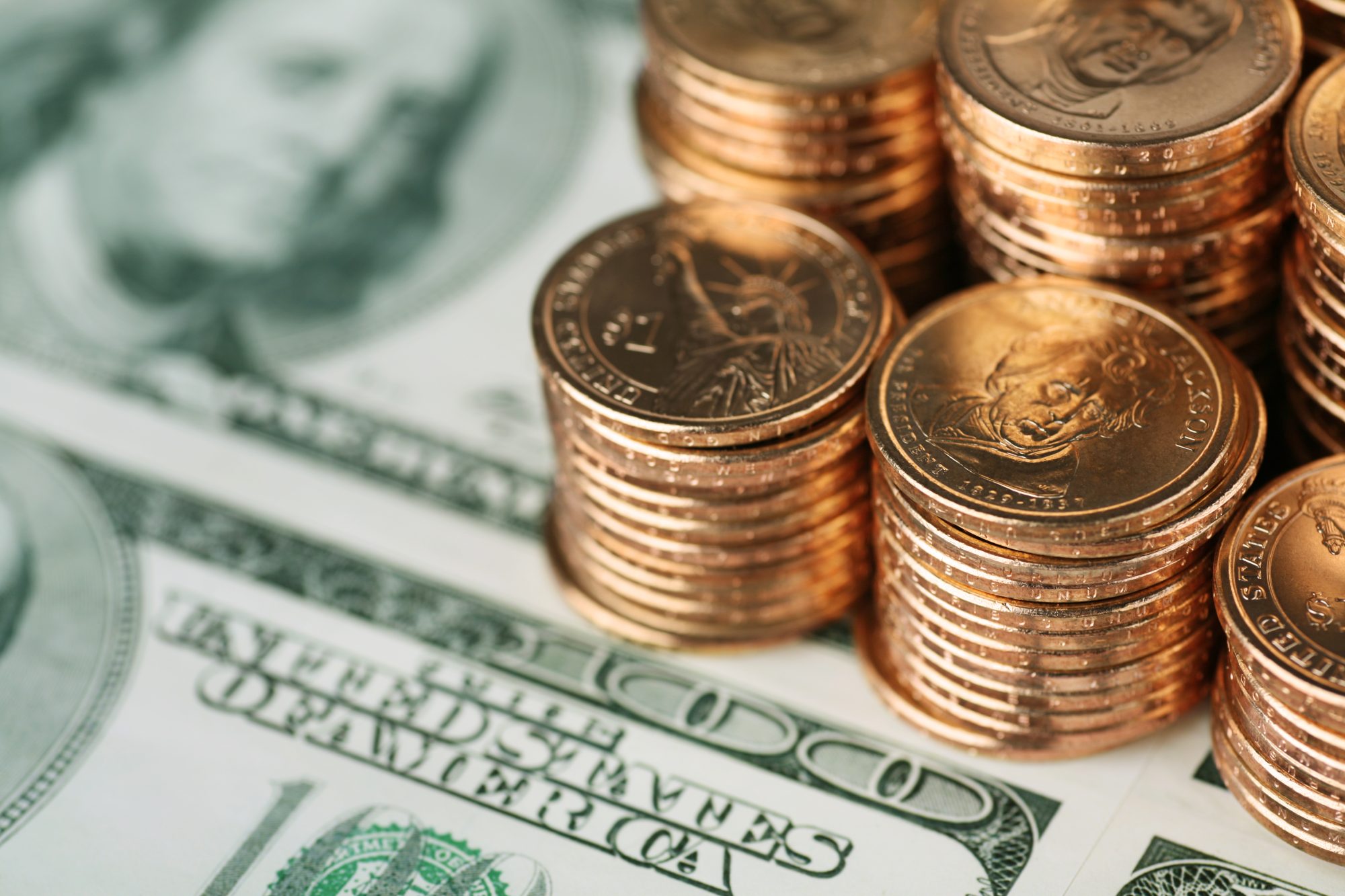 Close up of Gold coins and $100 bills.